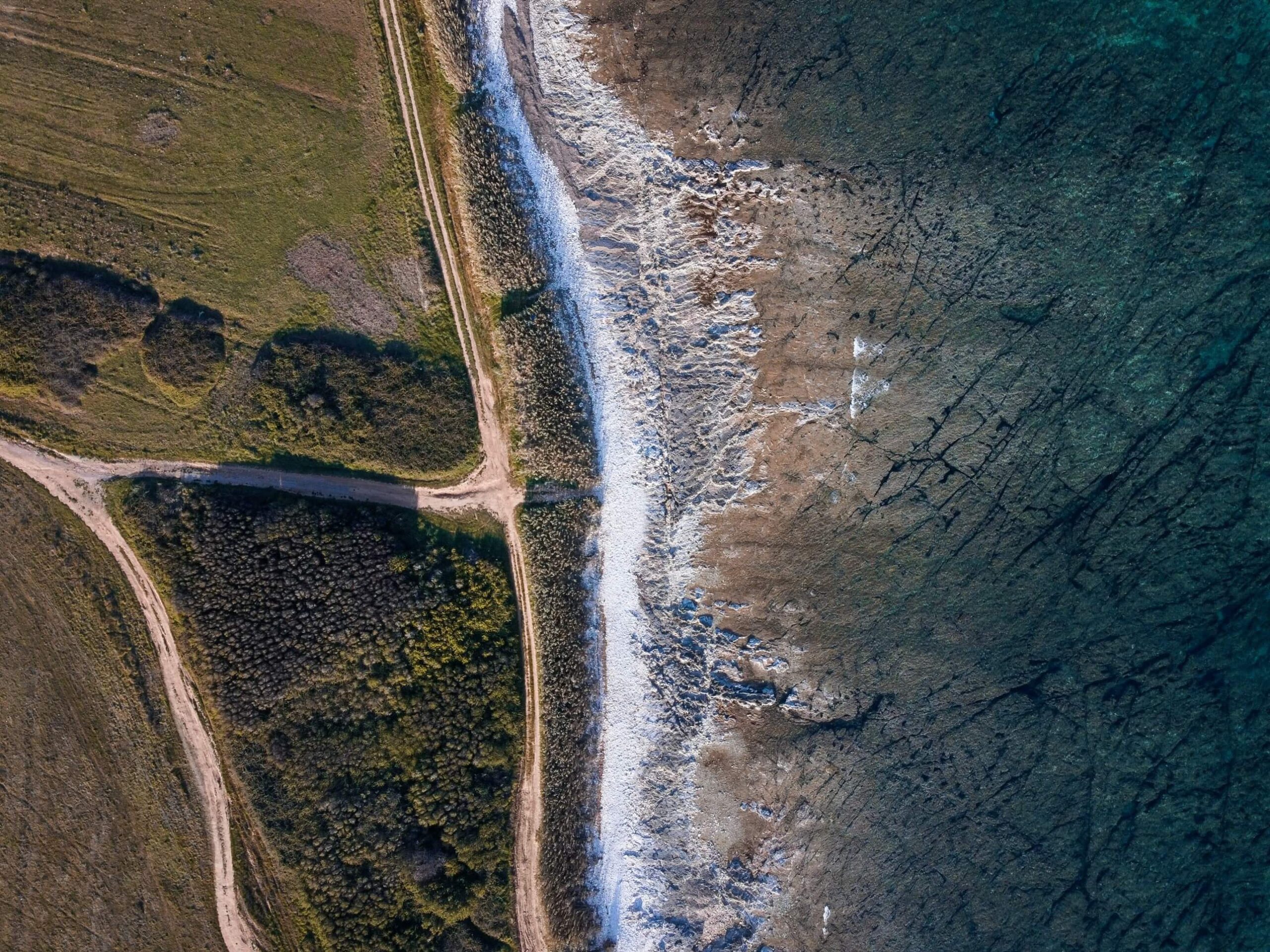 Slika s ptičje perspektive, obala pri Ližnjanu se stika z morjem.